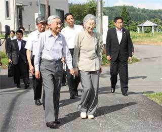 仮設住宅敷地内を歩く両陛下の写真