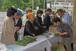 山菜を買い求める参加者の写真